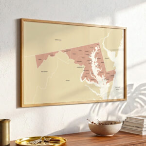 Maryland county map print in a wooden frame displayed on a wall above a wooden shelf in bright natural light.