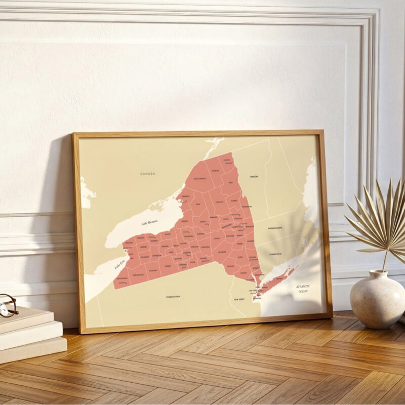 Large framed New York map leaning against a wall on wooden flooring, styled as minimalist home décor.