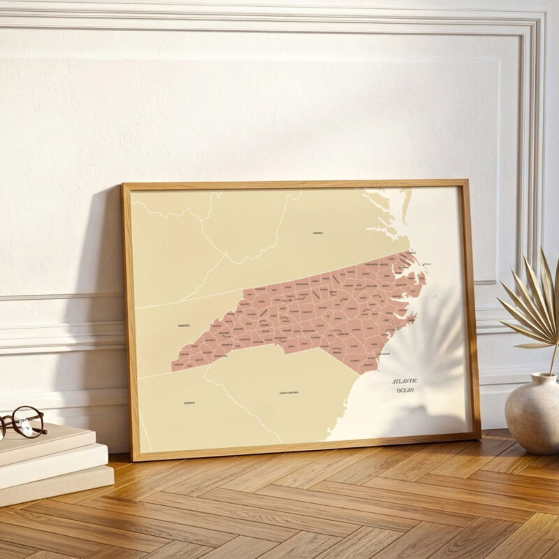 North Carolina map print leaning against a wall beside decorative accents, styled in a warm, contemporary home setting.