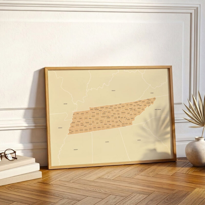 Large framed Tennessee map print resting against a white wall on a wooden floor, styled with soft natural lighting and minimal décor.