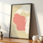A modern frame showcasing a Wisconsin state map resting on a wooden surface, highlighted by soft daylight and simple decorative pieces.